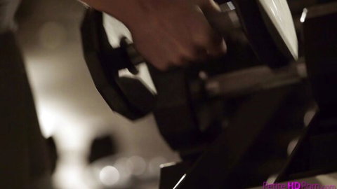 Muscular hands gripping heavy dumbbell in steamy gym workout closeup
