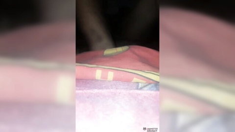 Blurry homemade closeup of pink fabric with yellow McDonald's logo on bed sheets