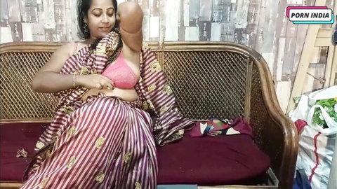 Indian stepmom Tarpita in striped saree and pink blouse, posing on sofa