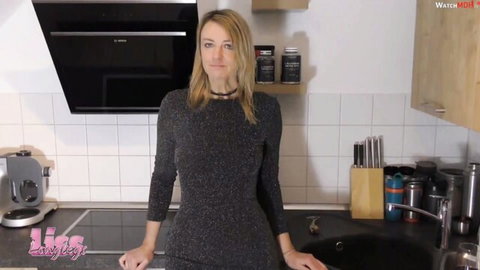 Blonde MILF in tight sparkly black dress teasing naughtily in kitchen