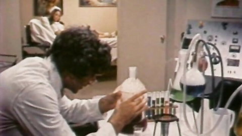 Vintage porn thumbnail of nerdy guy in lab coat with busty woman in background