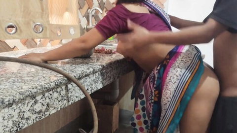 Indian wife bent over kitchen sink with saree pulled up exposing big bare ass as man grabs her hips from behind