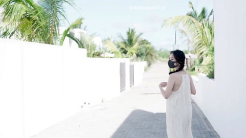 Chinese amateur in backless white dress walks tropical path, POV 4K