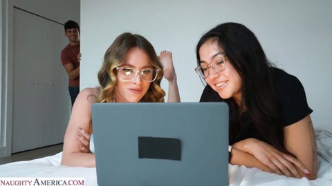 Anya Olsen and sexy friend on bed with laptop, guy peeking in