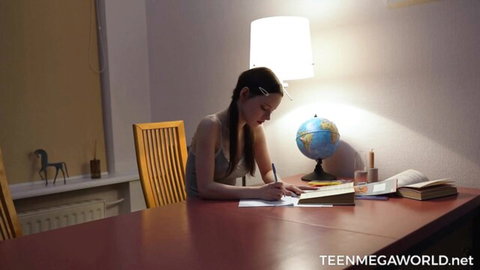 Skinny brunette teen student with small tits writes homework at desk in tight tank top