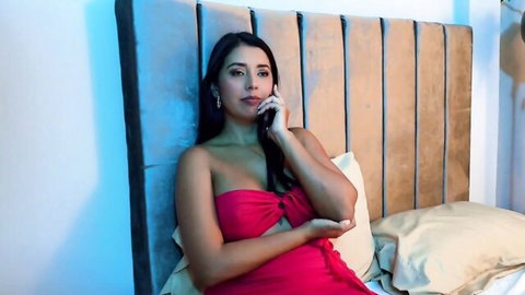 Angel Cruz in seductive pink tube dress on bed
