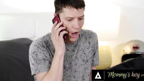 Surprised stepson in gray shirt talking shocked on red phone in Mommy's boy bedroom
