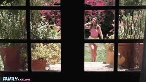 Lucky Anne curvy Latina in pink crop top and shorts, looking back seductively outdoors