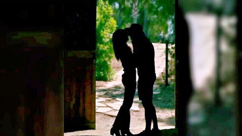 Silhouette of passionate couple deeply kissing in outdoor doorway