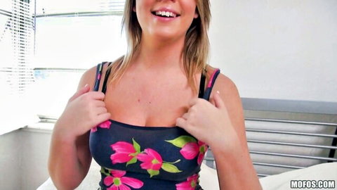 Alexis Adams smiling teasingly in floral top, showing cleavage