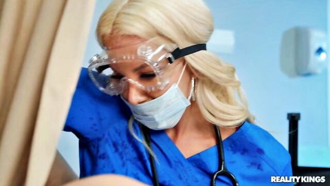 Blonde nurse MILF in blue scrubs mask and goggles leaning forward teasing in hospital