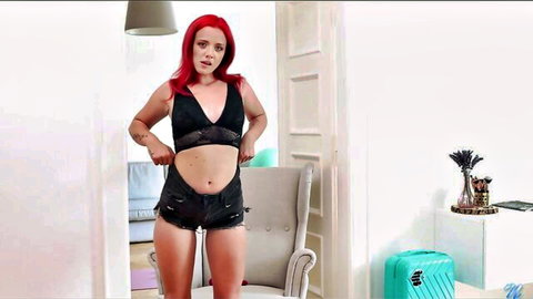 Sexy redhead with small tits and long hair teases in black lace bra and shorts