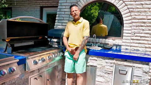 Tanned man in yellow polo and green shorts at outdoor grill with Jayla Page in Brazzers scene