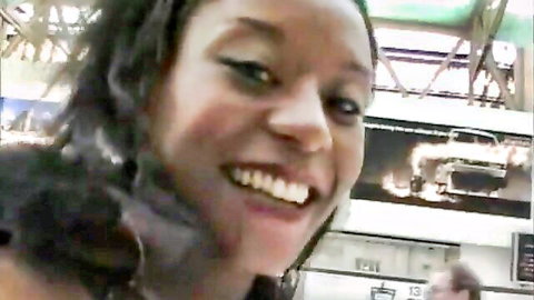 Smiling ebony woman with curly hair in public, teasing kinky vibe