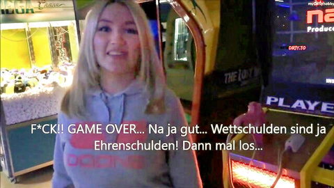 Lana-Giselle in hoodie at arcade, smiling for POV domination game