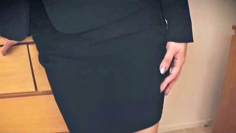 Sexy Asian office babe in tight black skirt and blazer posing seductively by desk