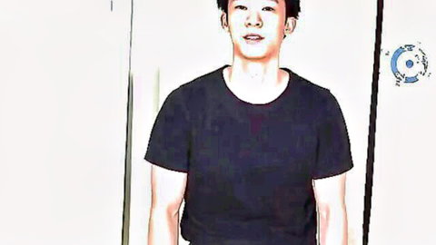 Young Asian guy smiling in tight black t-shirt posing solo in steamy bathroom