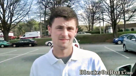 Young white guy in white polo smiling in parking lot for gay BBC interracial preview