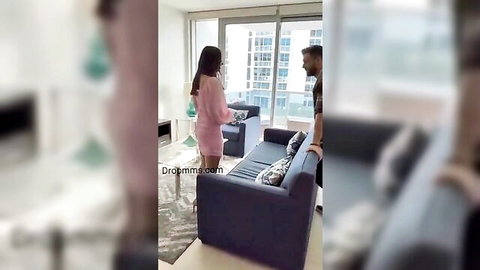 Amateur couple flirting, woman in short pink dress by window