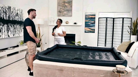 Curvy brunette in white shorts stands with muscular guy by black hot tub ready for steamy fuck