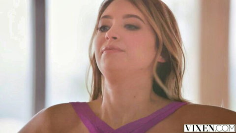 Seductive young blonde with long hair in tight purple top showing her fair skin and medium tits