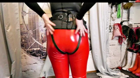 LadyKarame in tight red latex pants and black corset, BDSM domination pose from behind