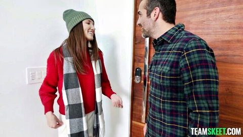 Maya Woulfe in festive red sweater and scarf greets man at door for Christmas fun