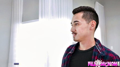 Handsome Asian man smirking sideways in plaid shirt against bright window