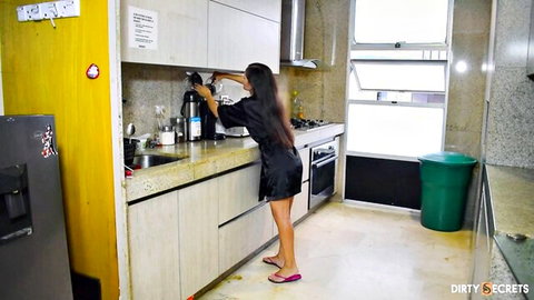 Asian stepmom in short black robe pouring coffee on Xmas morning