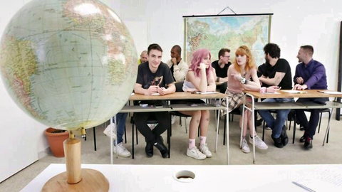 Rebel Rhyder with pink hair in schoolgirl outfit, group in classroom setup
