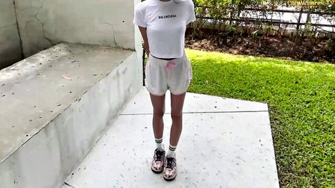 Petite babe in Balenciaga crop top and tight white shorts posing outdoors teasing her curves