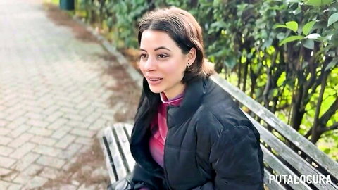 Lulita Star, sexy Spanish babe in pink top and black coat on outdoor bench