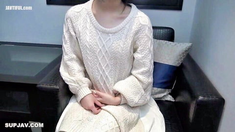 Cute 18-year-old Asian girl smiling in cozy white sweater and skirt
