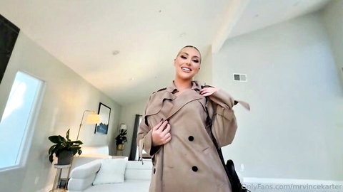 Kayley Gunner teases in open trench coat, smiling seductively