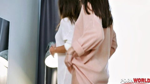 Two skinny brunette teens in oversized sweaters posing from behind in bedroom mirror
