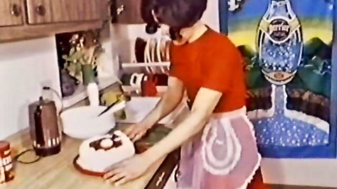 Busty retro housewife in apron baking cake in kitchen
