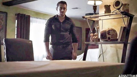 Handsome man in black shirt stands in dimly lit room for shemale anal orgy scene