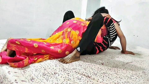 Indian woman in pink saree posed doggy style by man in black pants on bed