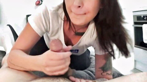 Smiling brunette MILF grips throbbing hard cock close to her mouth in homemade kitchen