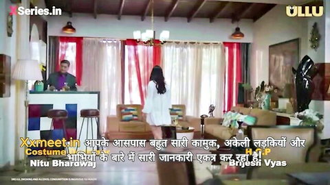 Sexy Indian woman in short white dress stands at bar with handsome man serving drink in steamy room scene