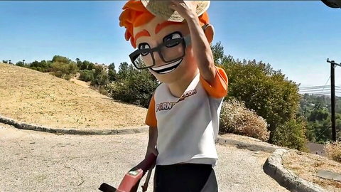 Padres mascot Barney in orange hair glasses tipping sombrero on sunny hillside