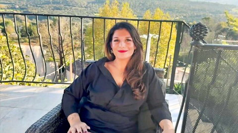 Lola, voluptuous French nurse in sexy black wrap dress on balcony