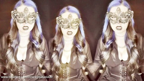 Mistress Betaslaver in ornate gold mask and corset, purple hair and cleavage tease