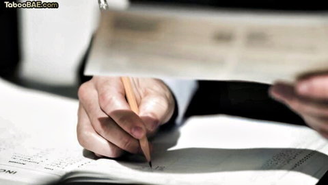Close-up of hands holding pencil writing on notebook paper