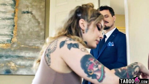 Tattooed brunette wife in tank top flirts intimately with suited bearded husband