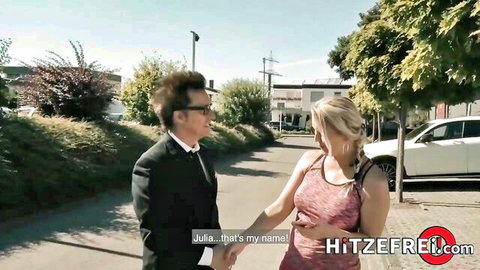 Julia Pink in pink top holding hands with suited man outdoors