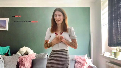 Emmasweetsugar smiles in white blouse and plaid skirt, tattoos on arms