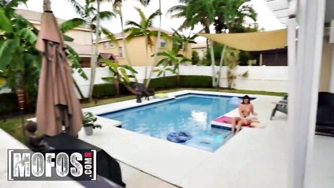 Vivian Taylor in skimpy bikini lounging poolside