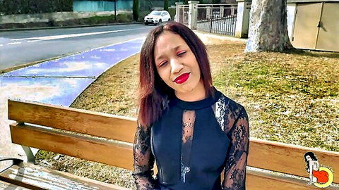 Sexy ebony teen in sheer lace dress teases cleavage with pouty lips on park bench