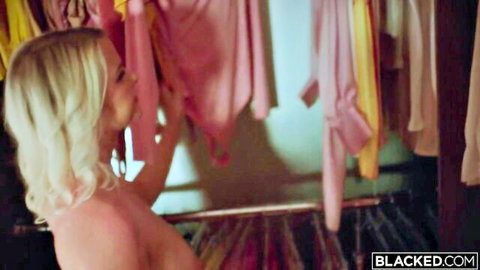 Topless blonde babe with sideboob reaching for pink clothes in closet